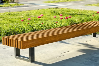 Photo of Wooden bench in city park on sunny morning