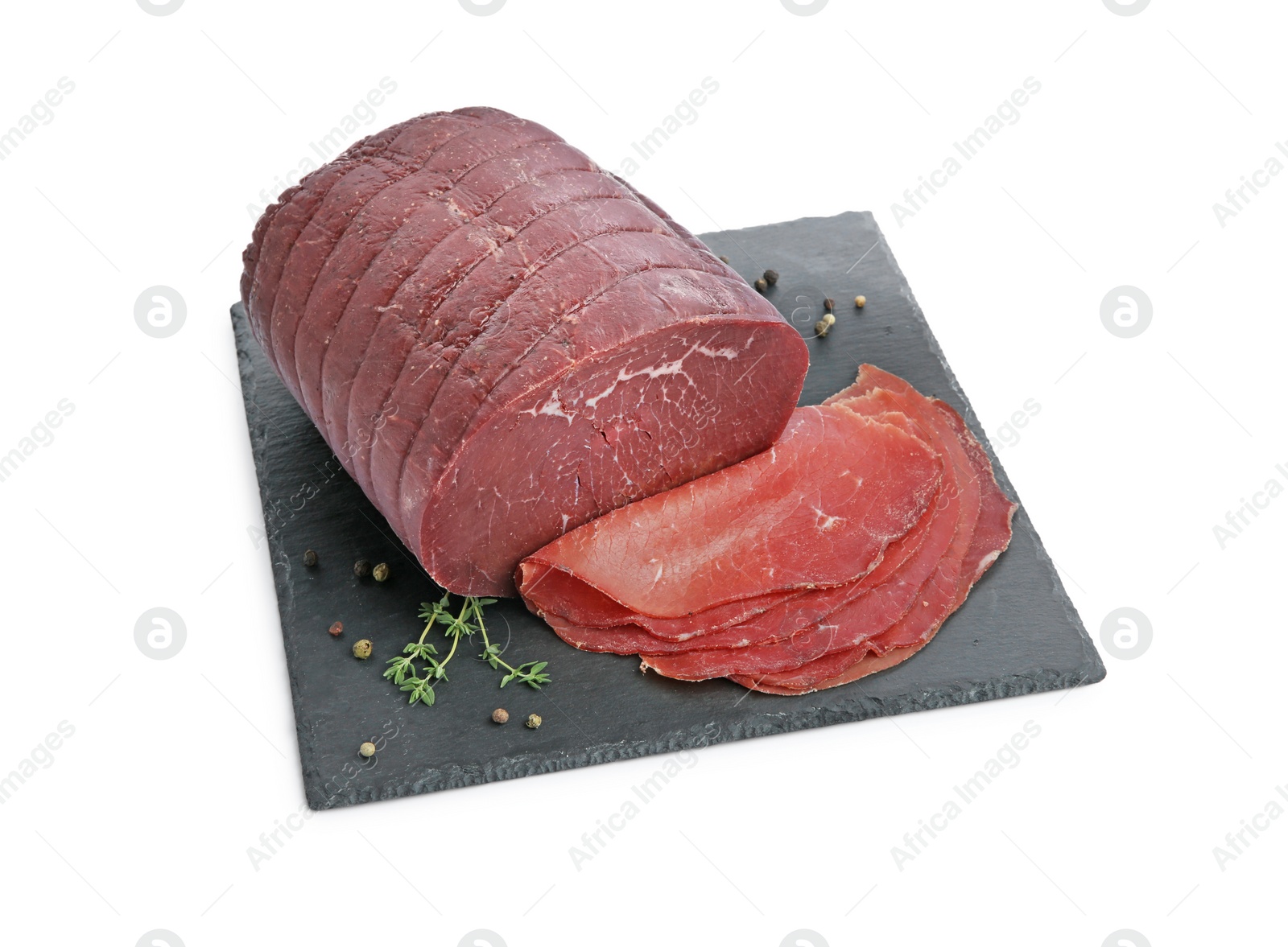 Photo of Tasty fresh dry bresaola, peppercorns and thyme isolated on white