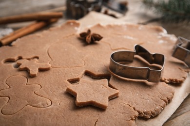 Photo of Making Christmas cookies. Raw dough and mitten shaped cutter on table, closeup