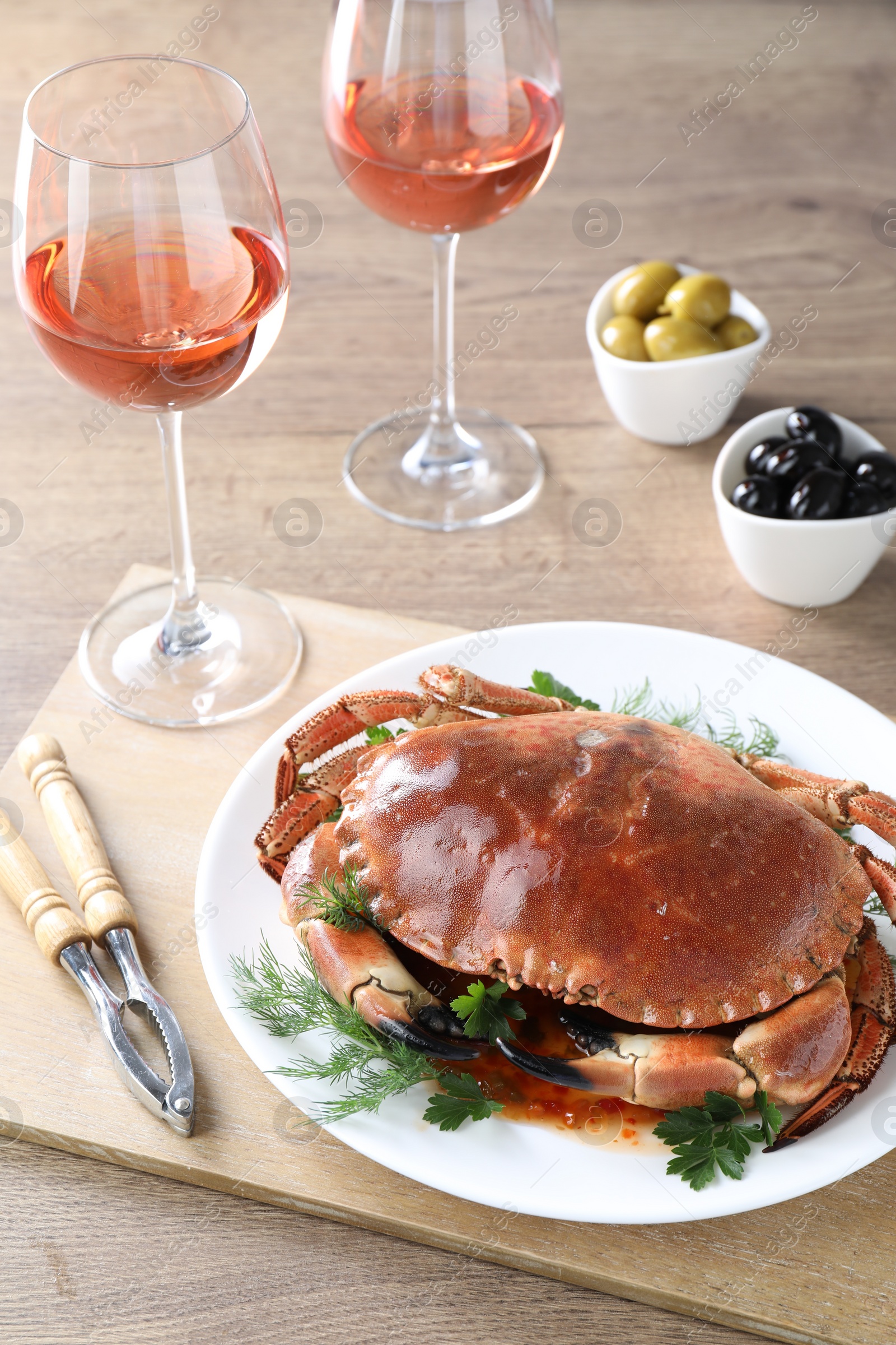 Photo of Delicious crab with greens served on wooden table