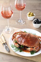 Photo of Delicious crab with greens served on wooden table