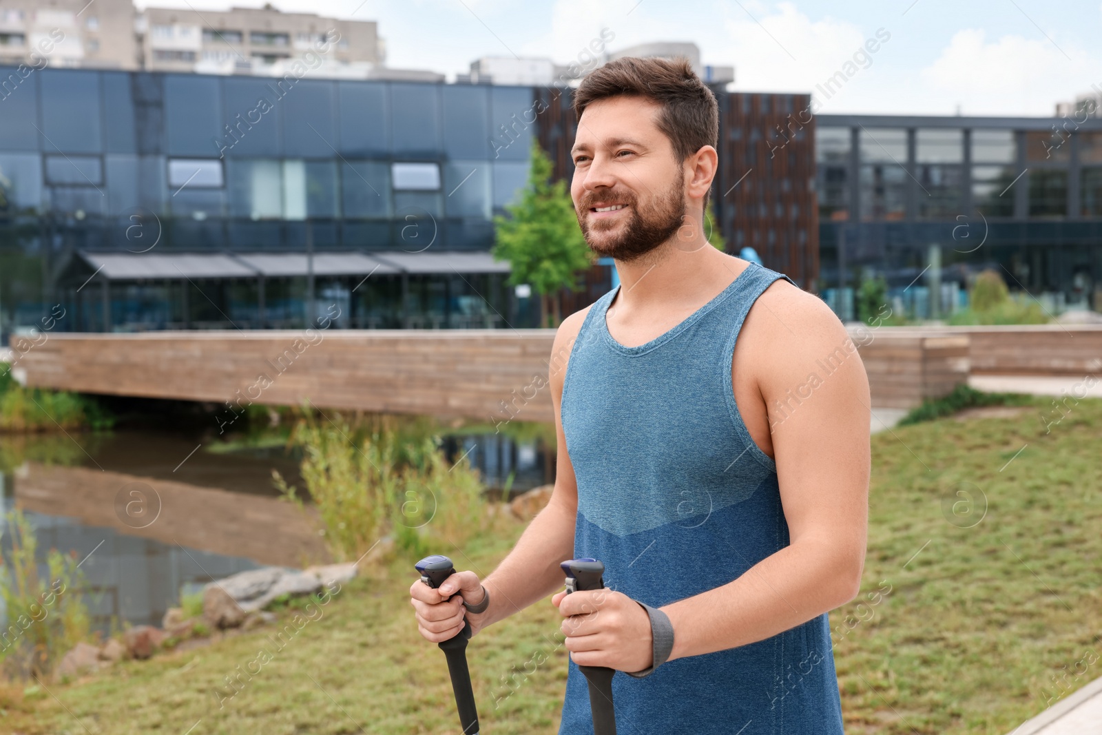 Photo of Man practicing Nordic walking with poles outdoors