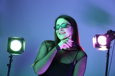 Photo of Portrait of beautiful young woman with sunglasses in photo studio