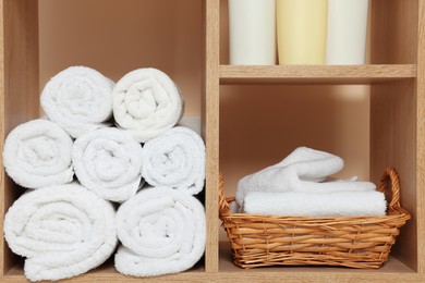 Photo of Fresh soft folded towels on wooden rack