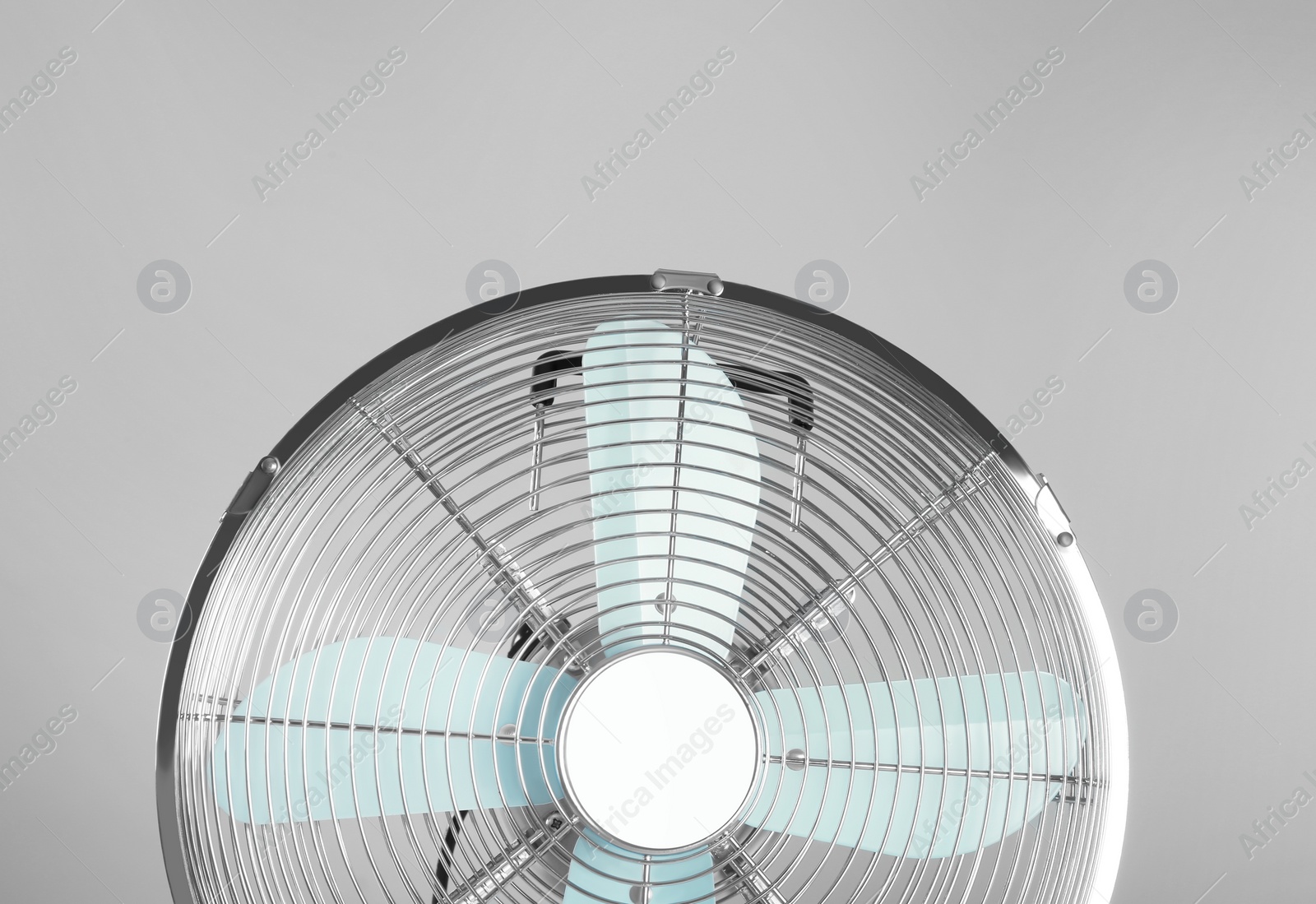 Photo of Electric fan on light grey background. Summer heat