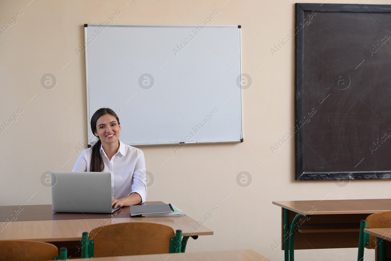 Photo of Female teacher at her desk in classroom