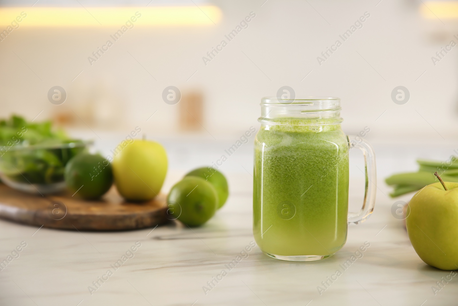 Photo of Tasty fresh juice in mason jar on table indoors. Space for text