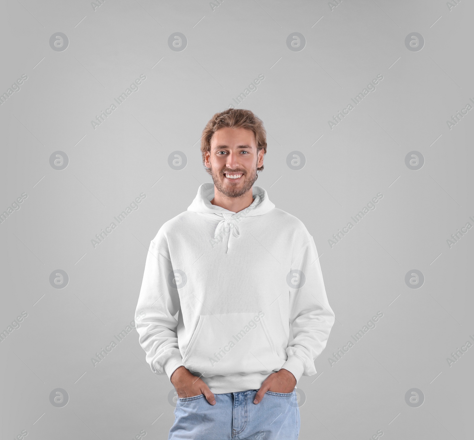 Photo of Portrait of man in hoodie sweater on light background. Space for design