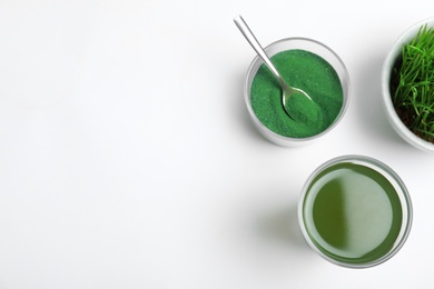 Composition with glass of spirulina drink on white background, top view