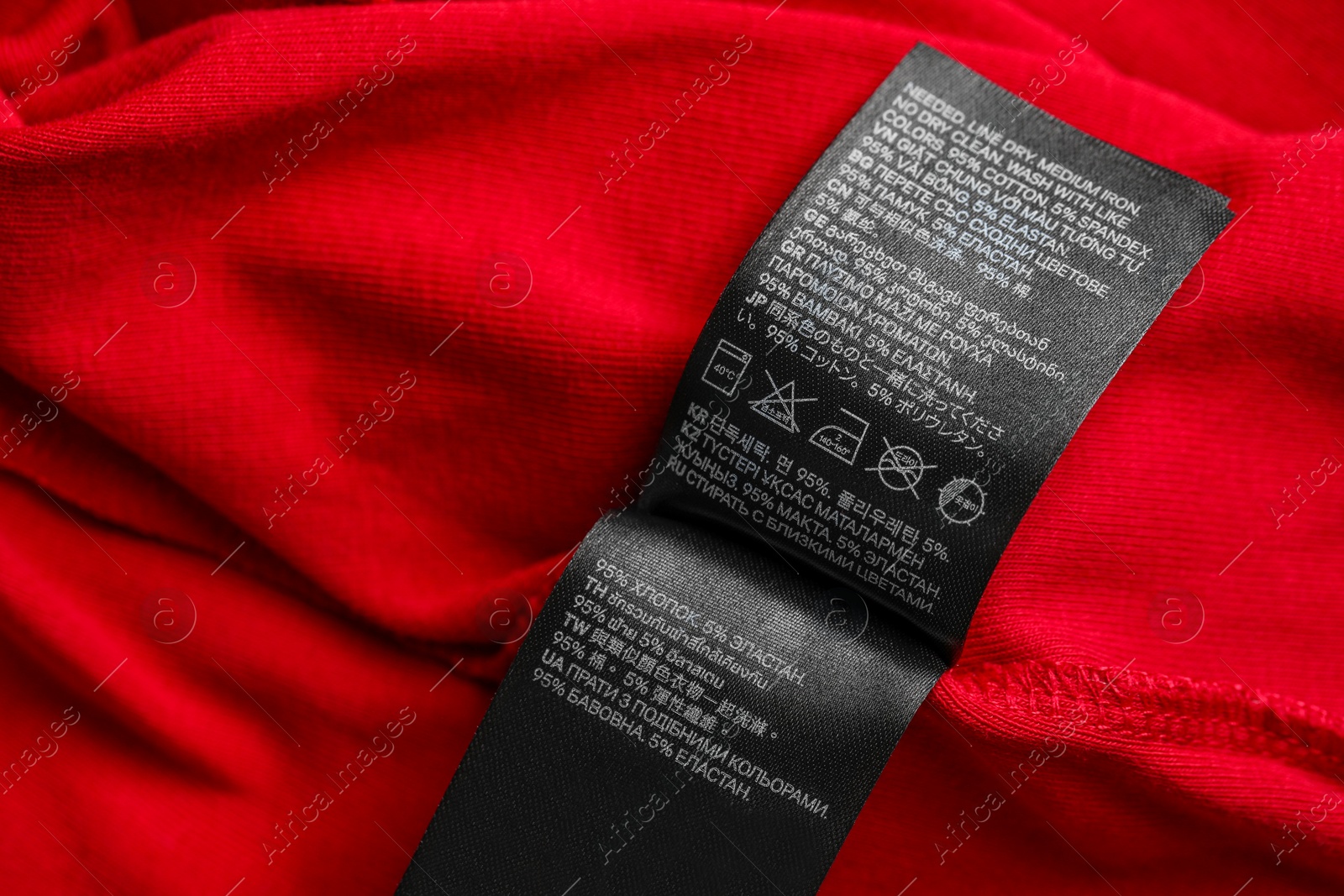 Photo of Black clothing labels on red garment, top view