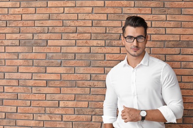 Photo of Portrait of handsome young man and space for text on brick wall background