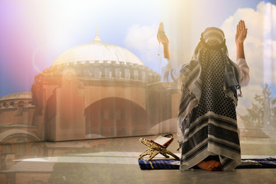 Image of Double exposure of Muslim man praying and mosque