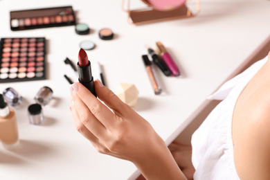 Photo of Beauty blogger with lipstick at table, closeup