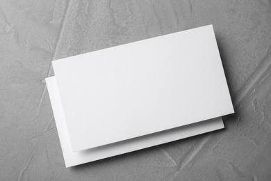 Blank business cards on light grey stone background, top view. Mock up for design