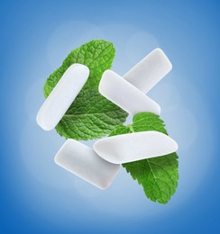 Image of Fresh mint leaves and chewing gum pads falling on blue background