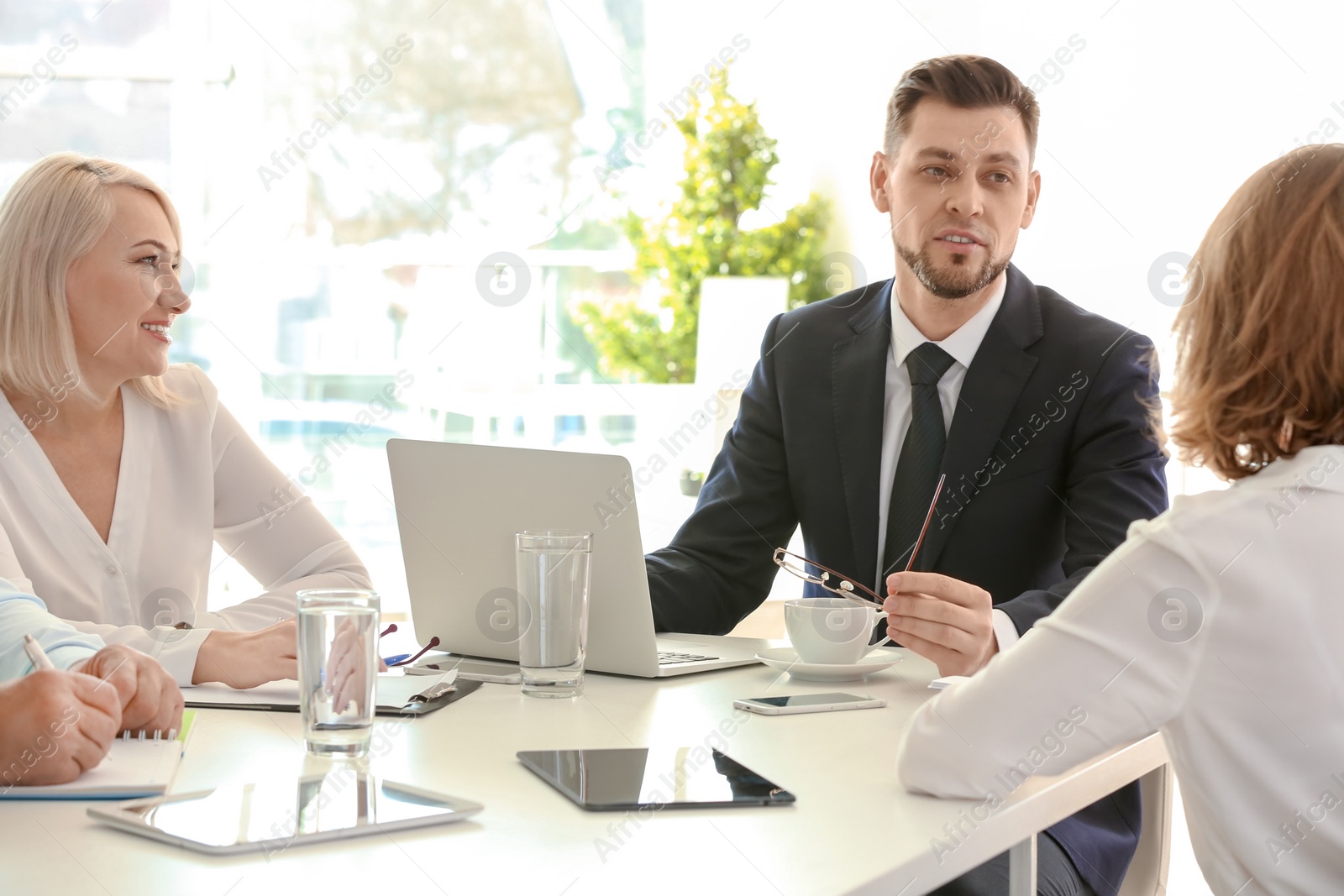 Photo of Group of people discussing ideas at table in office. Consulting service concept