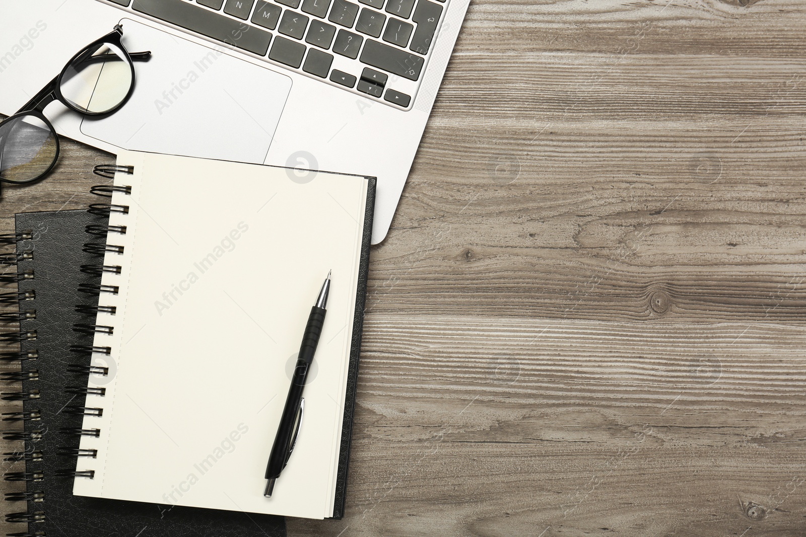 Photo of Flat lay composition with notebooks and laptop on wooden table, space for text