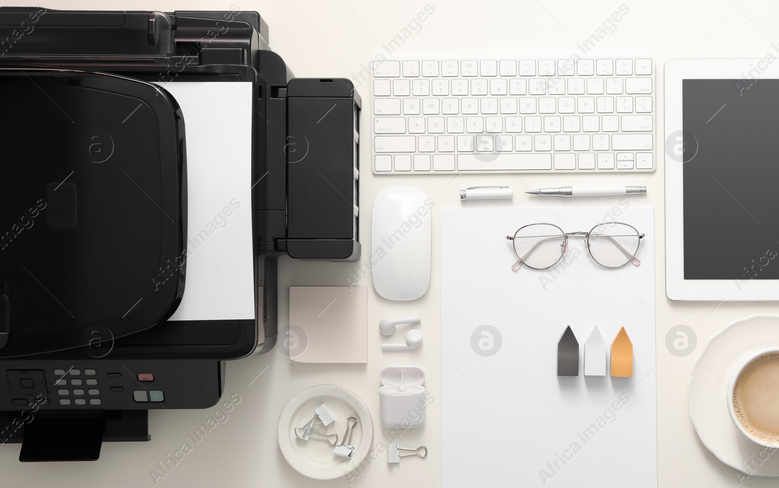 Photo of New modern printer, tablet and office supplies on white table, flat lay