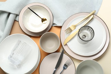 Photo of Clean plates, bowls, glasses and cutlery on table, flat lay