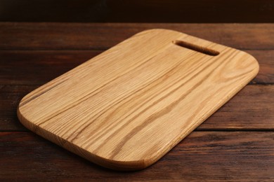 Photo of One new cutting board on wooden table, closeup