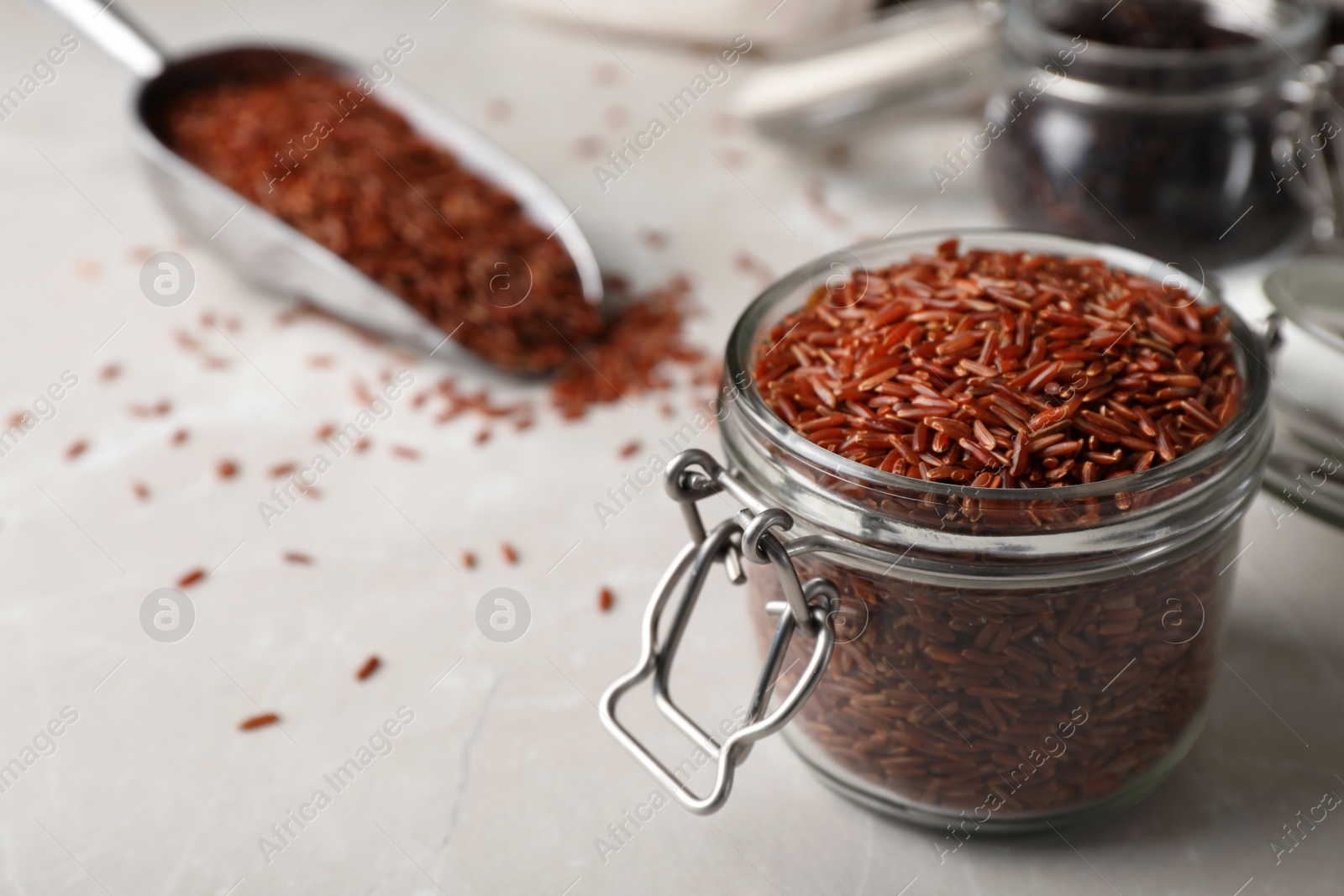 Photo of Brown rice in glass jar on table. Space for text