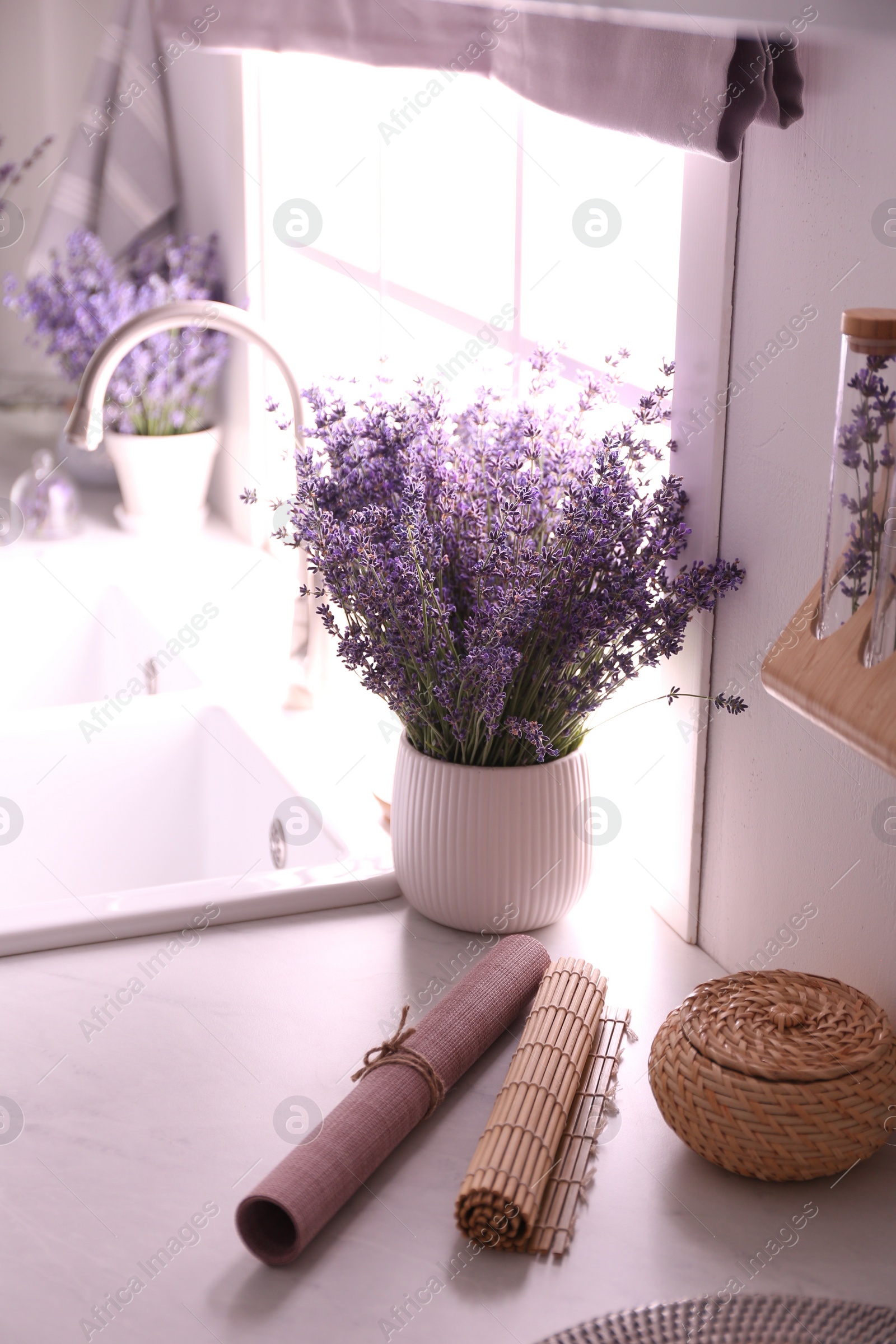 Photo of Beautiful lavender flowers on countertop near sink in kitchen