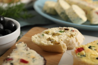 Photo of Different types of tasty butter and bread on table, closeup