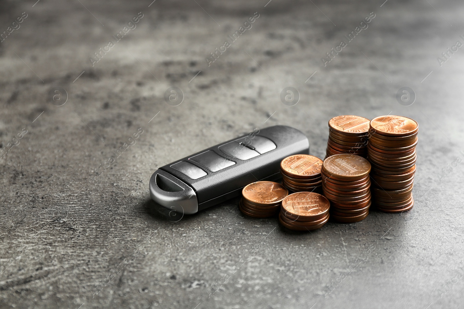 Photo of Car key and coins on grey background. Space for text