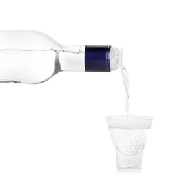 Pouring vodka from bottle in glass on white background