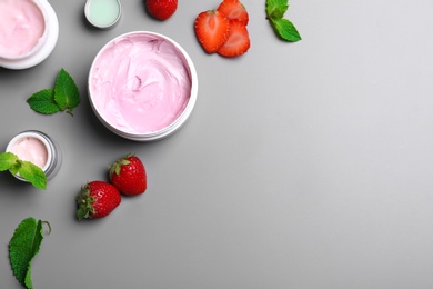 Flat lay composition with jars of body cream on grey background. Space for text