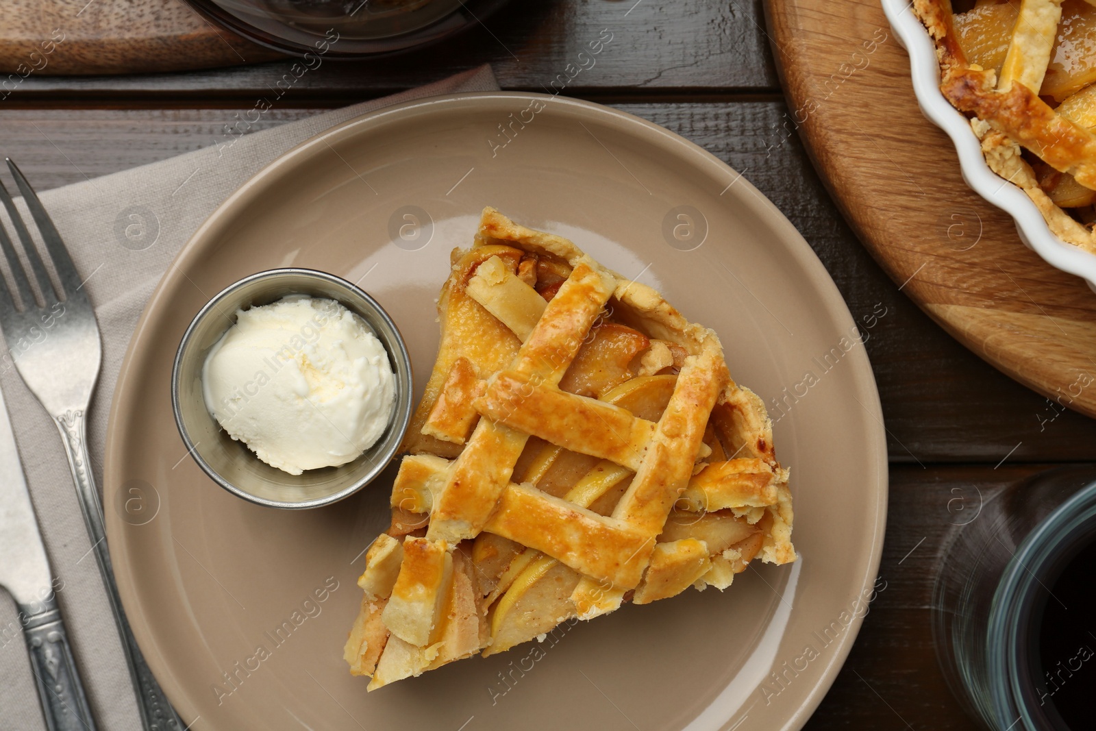 Photo of Piece of tasty homemade quince pie served on wooden table, flat lay