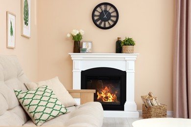 Photo of Stylish fireplace near comfortable sofa in cosy living room