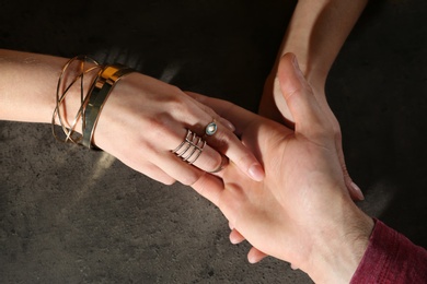 Photo of Chiromancer reading lines on man's palm at table, above view