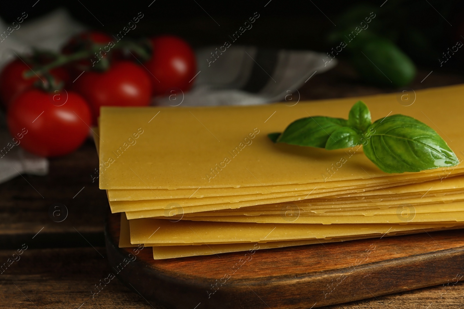 Photo of Composition with uncooked lasagna sheets on wooden table, closeup