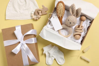 Photo of Flat lay composition with different baby accessories and blank card on yellow background