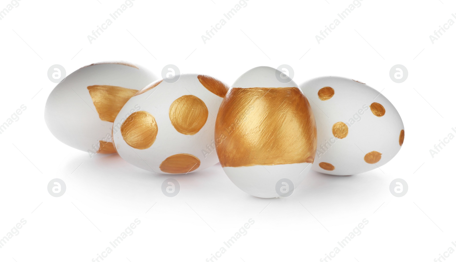 Photo of Set of traditional Easter eggs decorated with golden paint on white background