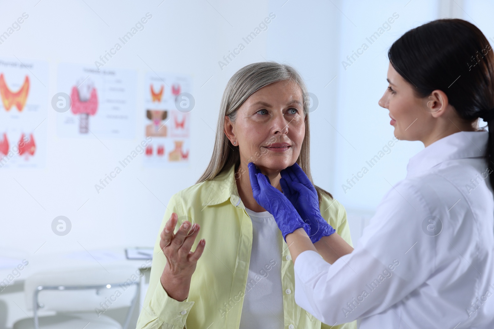 Photo of Endocrinologist examining thyroid gland of patient at hospital