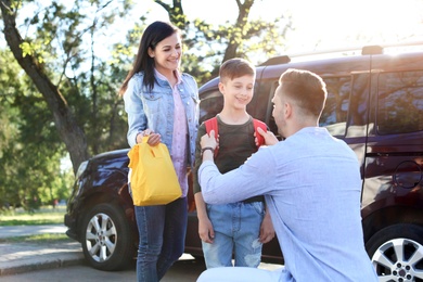 Photo of Young parents saying goodbye to their little child near school