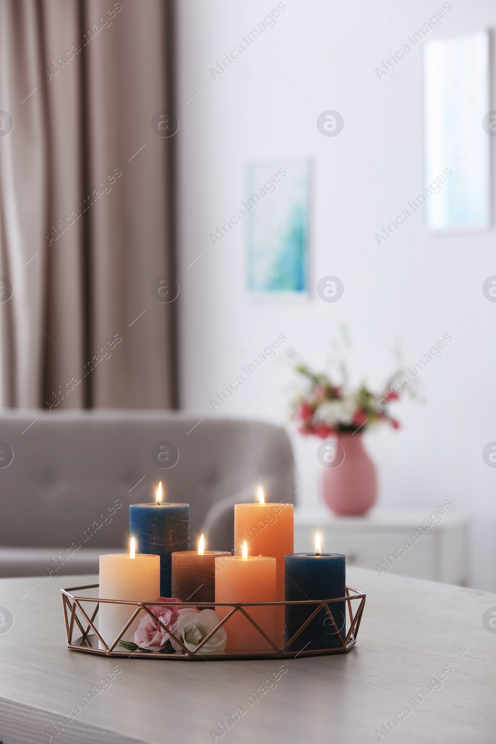 Photo of Tray with burning candles and flowers on table in living room. Space for text