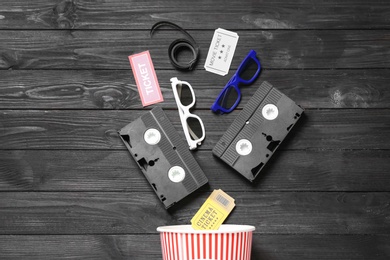 Flat lay composition with cinema entertainment items on black wooden background