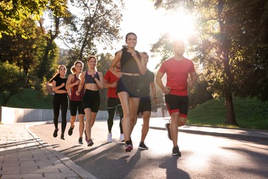 Photo of Group of people running outdoors on sunny day