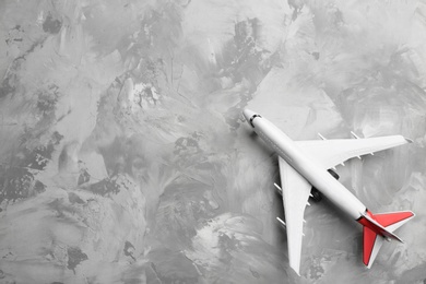 Photo of Toy airplane on grey background, top view. Space for text