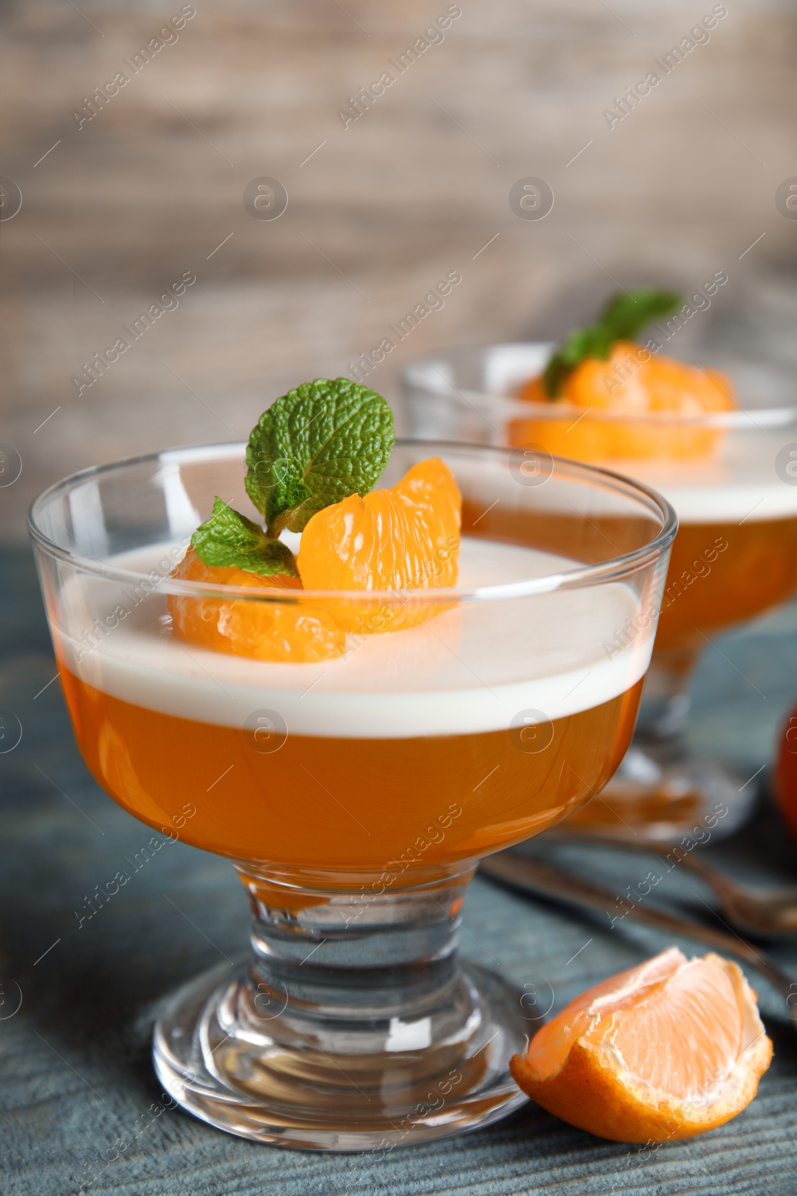 Photo of Delicious tangerine jelly on light blue wooden table, closeup