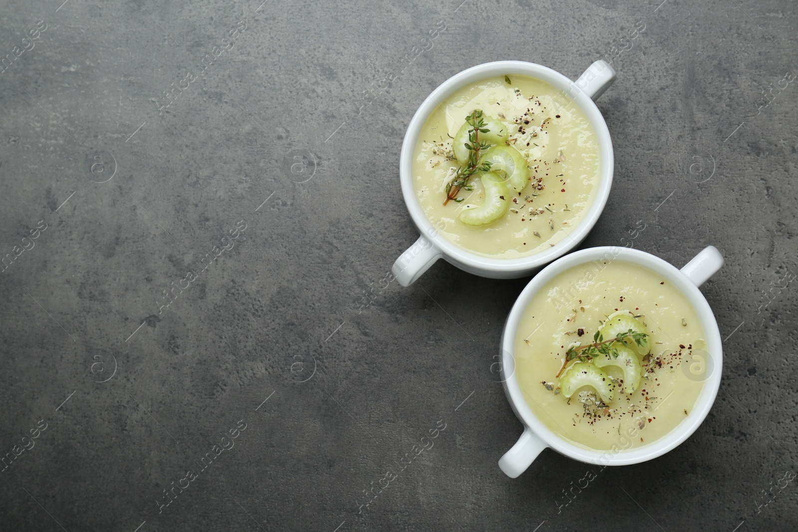 Photo of Delicious celery soup on gray table, flat lay. Space for text
