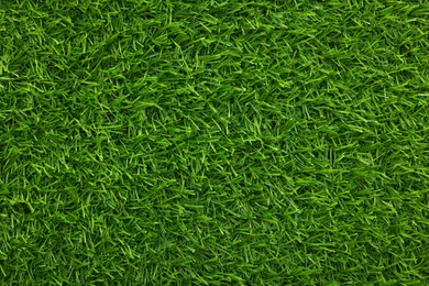 Photo of Green artificial grass as background, top view