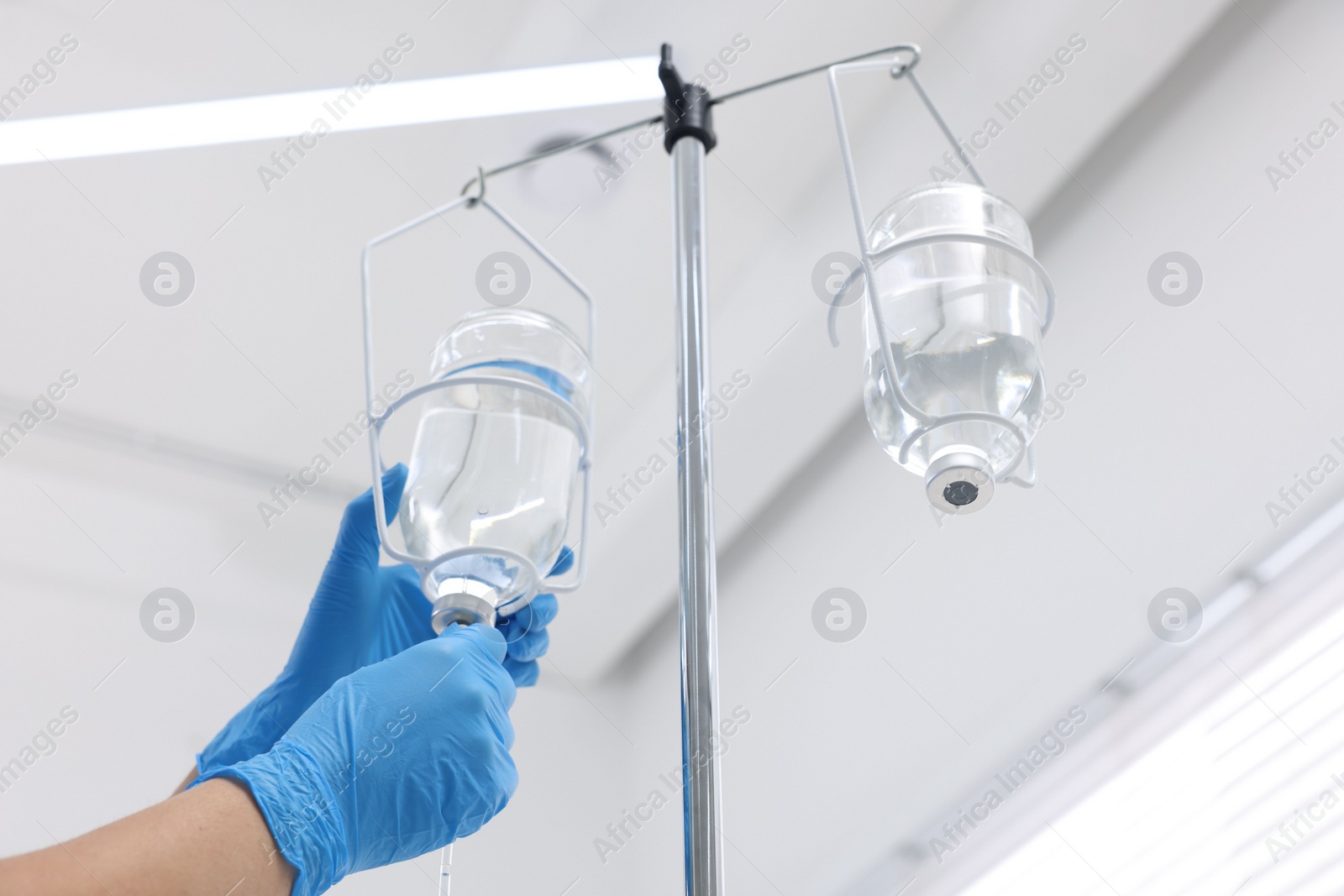 Photo of Nurse setting up IV drip in hospital, closeup