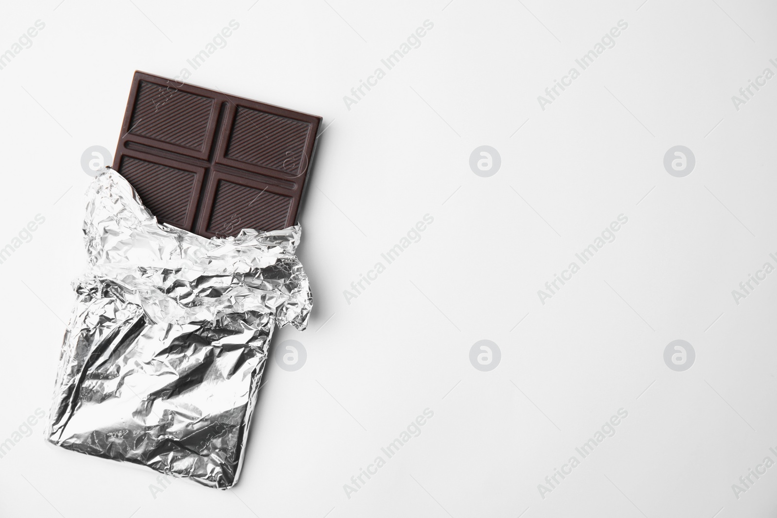 Photo of Tasty chocolate bar on white background, top view