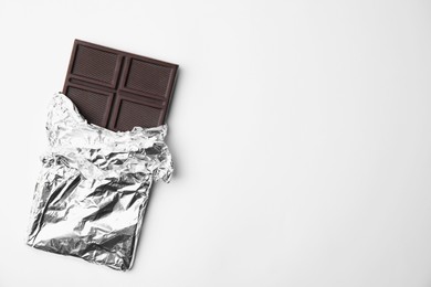 Tasty chocolate bar on white background, top view