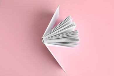 Photo of Hardcover book on pink background, top view