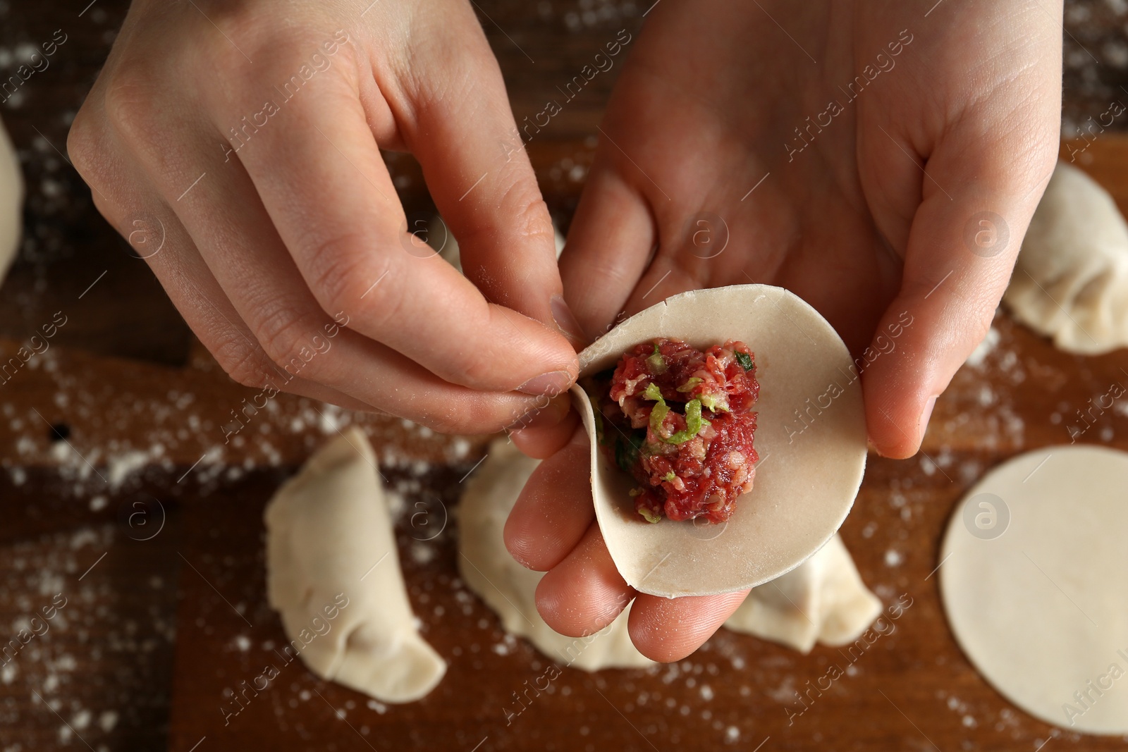 Photo of Woman making gyoza at table, above view